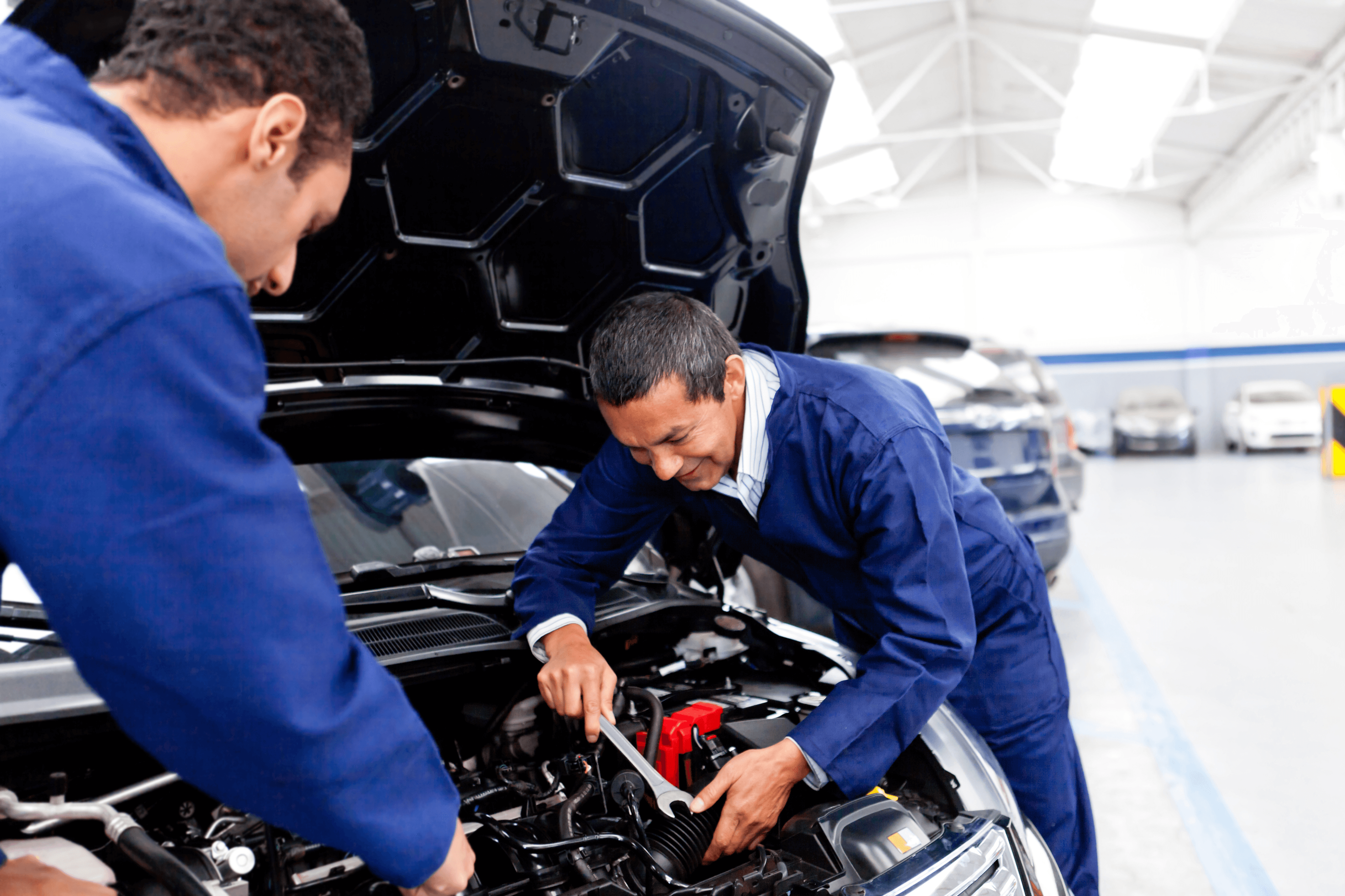 Two mechanics working together to fix the engine of a car